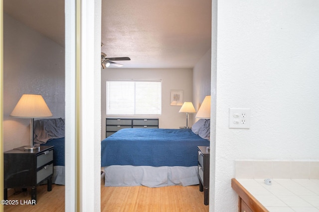 bedroom featuring a textured ceiling, ceiling fan, and wood-type flooring