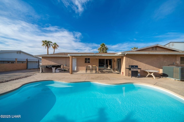 back of house featuring a patio area, a fenced in pool, and central AC