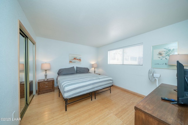 bedroom with light wood-type flooring and a closet