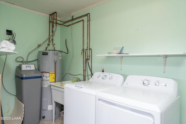 clothes washing area featuring washing machine and dryer, ornamental molding, and electric water heater