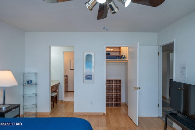 bedroom featuring a walk in closet, light hardwood / wood-style flooring, a closet, ceiling fan, and ensuite bathroom