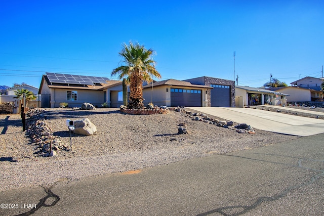 ranch-style house with a garage and solar panels