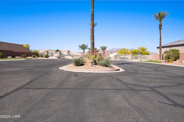 view of street featuring curbs, a residential view, a gated entry, and a gate