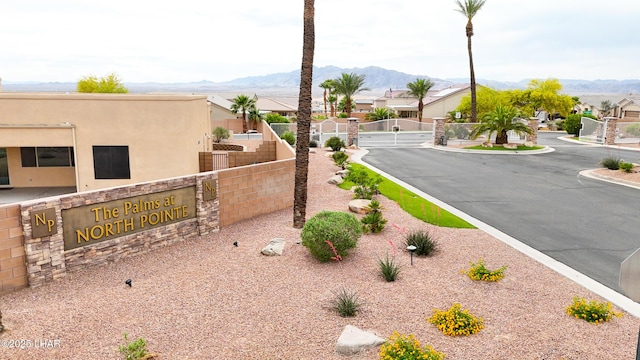 view of street with a residential view, a mountain view, curbs, a gated entry, and a gate