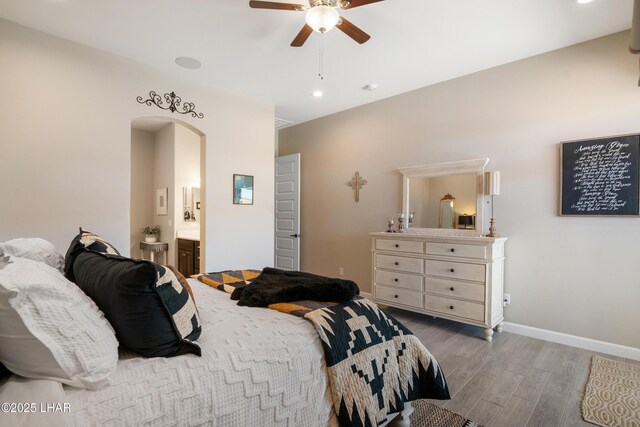bedroom featuring arched walkways, a ceiling fan, recessed lighting, wood finished floors, and baseboards