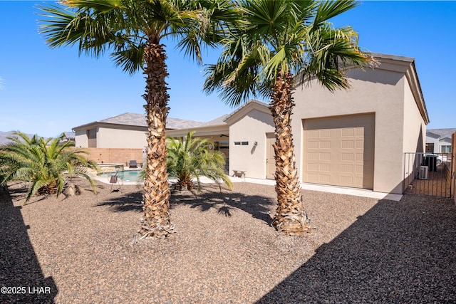 view of front of property with a fenced in pool, stucco siding, and fence