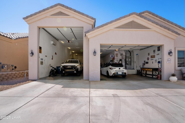 garage featuring concrete driveway, heating unit, and water heater
