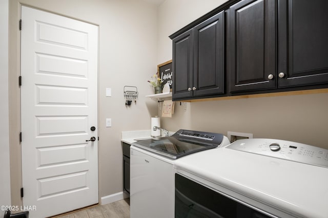 laundry area featuring separate washer and dryer, light wood finished floors, baseboards, and cabinet space