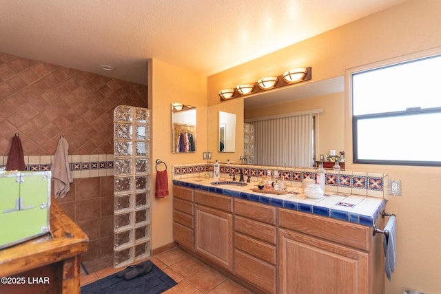 bathroom with vanity, walk in shower, a textured ceiling, and tile patterned floors