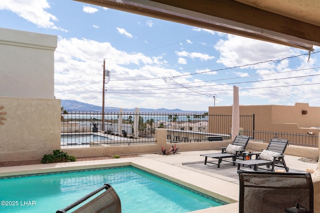 view of pool with a patio area, fence, a mountain view, and a fenced in pool