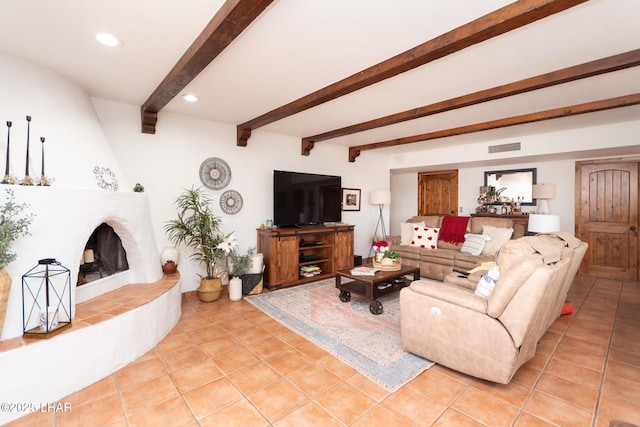 living room with recessed lighting, beamed ceiling, a tiled fireplace, and light tile patterned floors