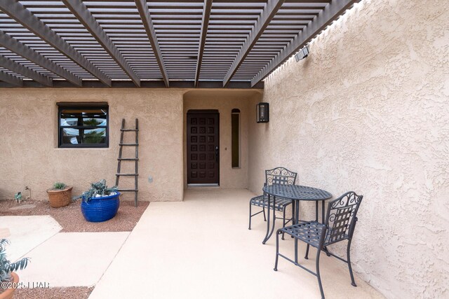 property entrance featuring a patio and stucco siding