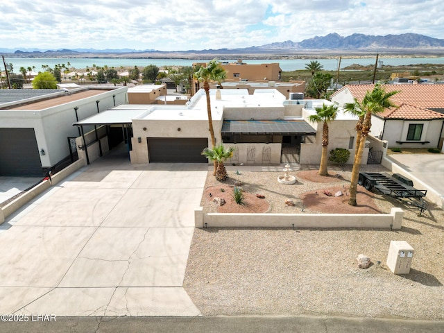 view of front of house featuring driveway, a garage, a residential view, a mountain view, and stucco siding