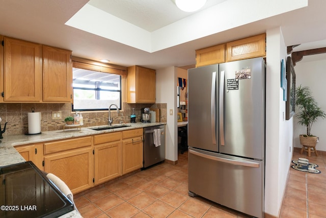 kitchen featuring light tile patterned flooring, stainless steel appliances, a sink, backsplash, and light stone countertops