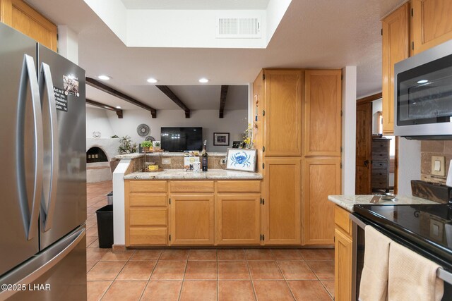 kitchen with open floor plan, stainless steel appliances, light tile patterned floors, and visible vents