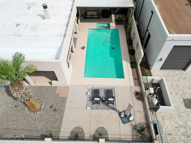 rear view of house featuring an outdoor pool, a patio area, and stucco siding