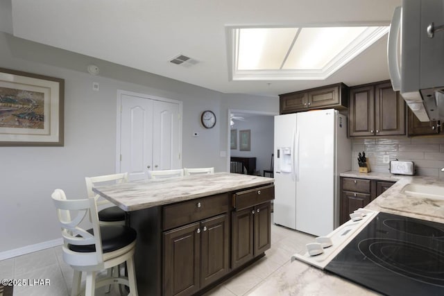777 Harrah Way Unit 524, Lake Havasu City, AZ 86403 - kitchen featuring tasteful backsplash, a kitchen breakfast bar, a center island, white fridge with ice dispenser, and dark brown cabinetry