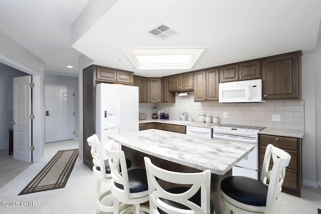 777 Harrah Way Unit 524, Lake Havasu City, AZ 86403 - kitchen with backsplash, white appliances, a center island, and a breakfast bar