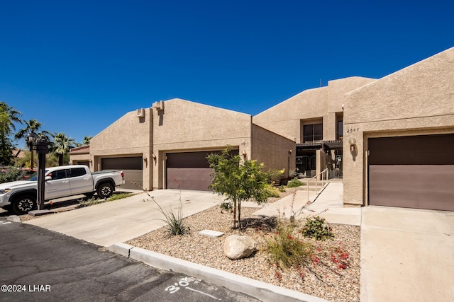 pueblo revival-style home with a garage