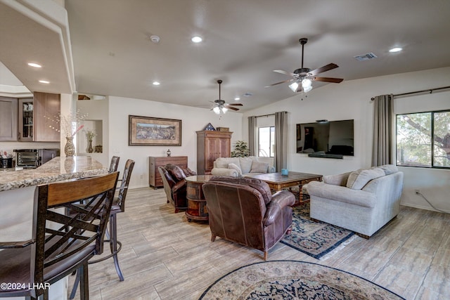 living room with ceiling fan and vaulted ceiling