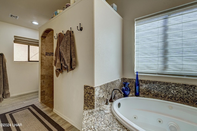 bathroom featuring tiled tub