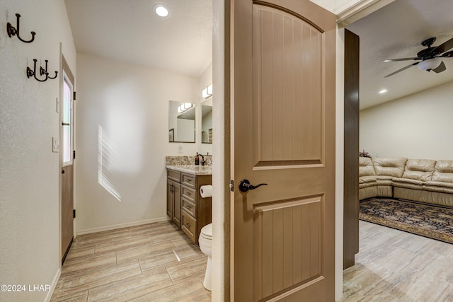 bathroom with vanity, hardwood / wood-style floors, toilet, and ceiling fan