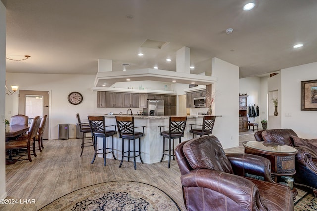 living room with light hardwood / wood-style flooring and vaulted ceiling