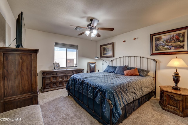 carpeted bedroom with a textured ceiling and ceiling fan