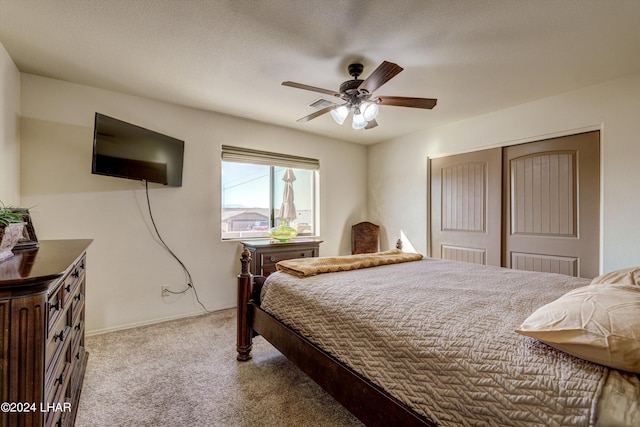 carpeted bedroom featuring ceiling fan, a closet, and a textured ceiling