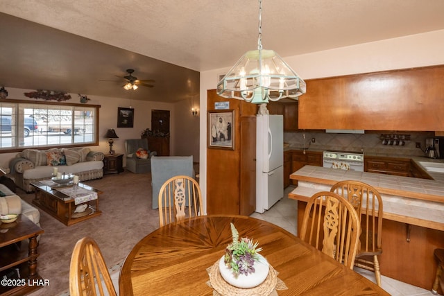 dining space featuring ceiling fan with notable chandelier and light tile patterned flooring