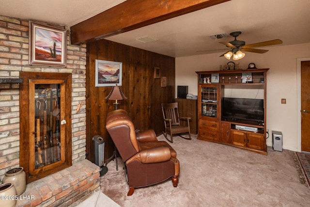 living area featuring visible vents, a ceiling fan, carpet floors, and beamed ceiling