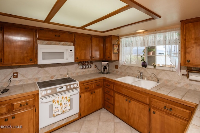 kitchen featuring tile counters, a sink, and white appliances