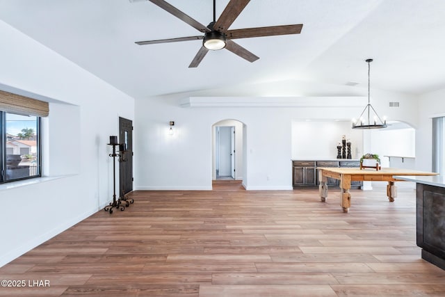 1921 Burgundy Ln, Lake Havasu City, AZ 86404 - unfurnished living room with vaulted ceiling, ceiling fan with notable chandelier, light wood-type flooring, arched walkways, and visible vents