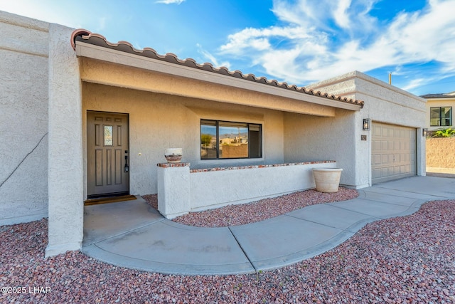 1921 Burgundy Ln, Lake Havasu City, AZ 86404 - view of exterior entry with stucco siding, driveway, and a garage