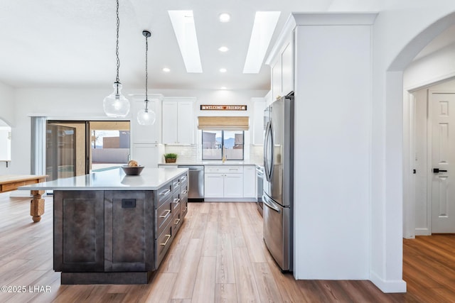 1921 Burgundy Ln, Lake Havasu City, AZ 86404 - kitchen featuring a sink, arched walkways, light countertops, white cabinets, and appliances with stainless steel finishes