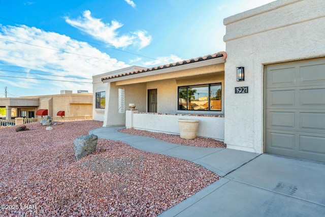 1921 Burgundy Ln, Lake Havasu City, AZ 86404 - view of exterior entry featuring covered porch, a tile roof, and stucco siding