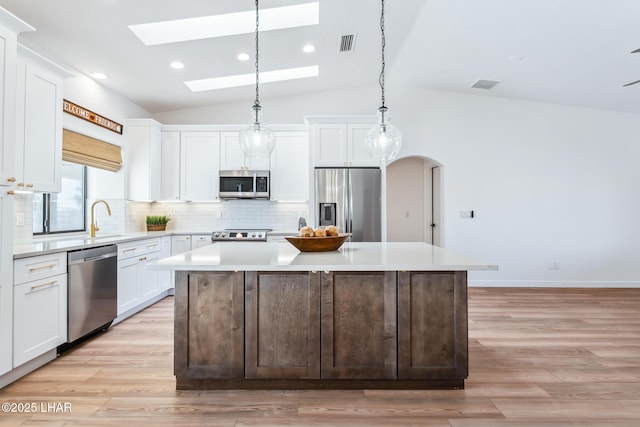 1921 Burgundy Ln, Lake Havasu City, AZ 86404 - kitchen with decorative backsplash, appliances with stainless steel finishes, white cabinetry, visible vents, and a kitchen island