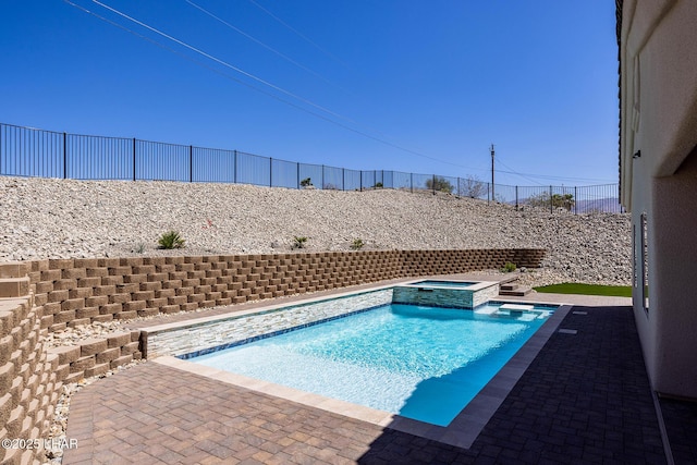 view of swimming pool featuring a patio, a pool with connected hot tub, and a fenced backyard