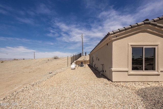 view of property exterior featuring stucco siding and a tiled roof