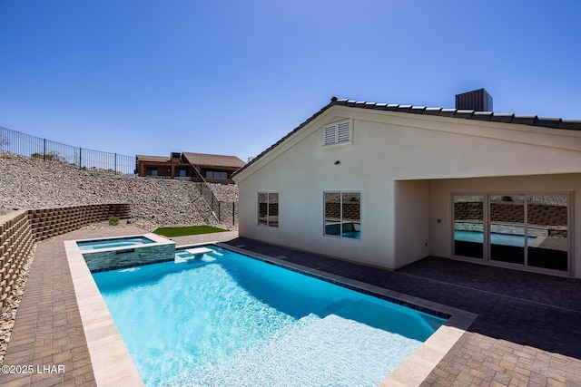 view of swimming pool featuring a patio, fence, central AC unit, and a pool with connected hot tub