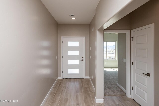 entryway with light wood finished floors, visible vents, and baseboards
