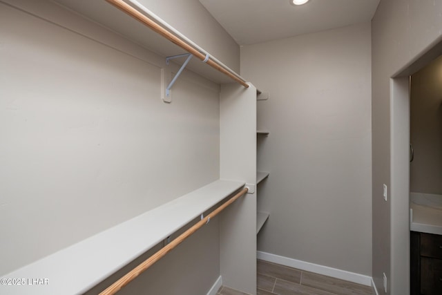 walk in closet with wood finished floors