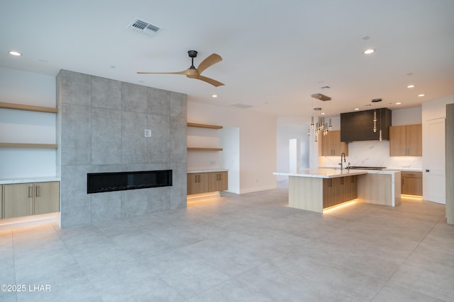 kitchen with visible vents, open floor plan, a fireplace, modern cabinets, and open shelves