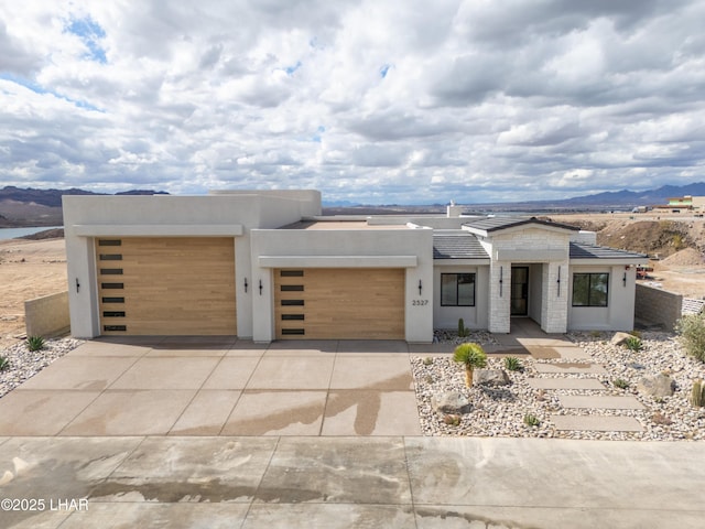 modern home featuring stucco siding, an attached garage, and driveway