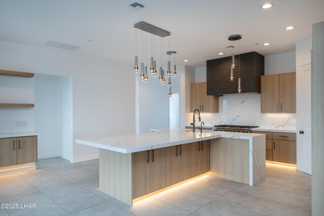 kitchen featuring a sink, light stone counters, modern cabinets, and light brown cabinetry