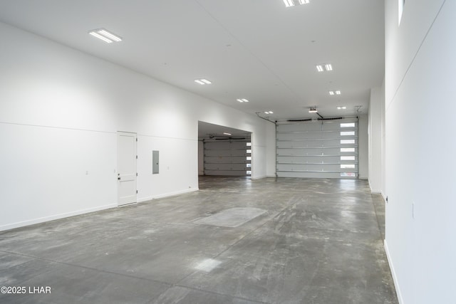 garage featuring electric panel and baseboards