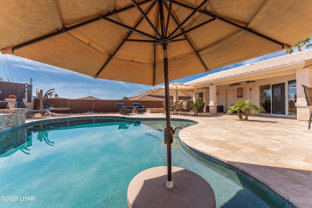 view of swimming pool with ceiling fan, a patio area, fence, and a fenced in pool