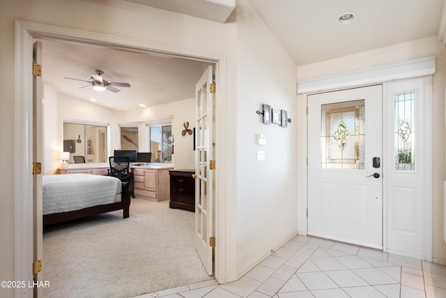 foyer entrance featuring ceiling fan, light tile patterned flooring, recessed lighting, light carpet, and vaulted ceiling