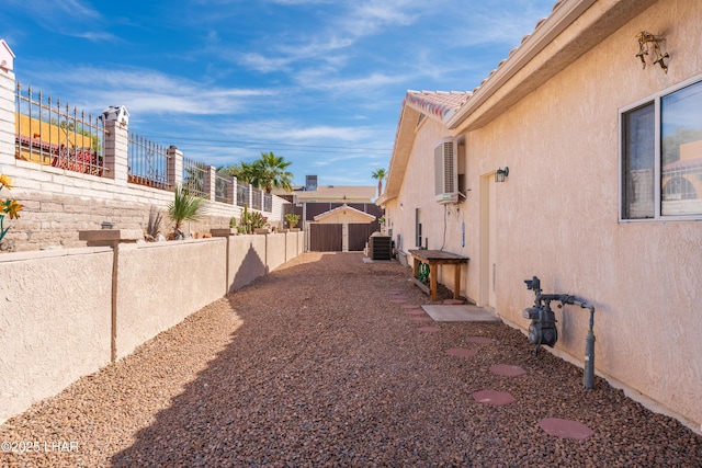 view of yard featuring an outbuilding, fence, and central air condition unit