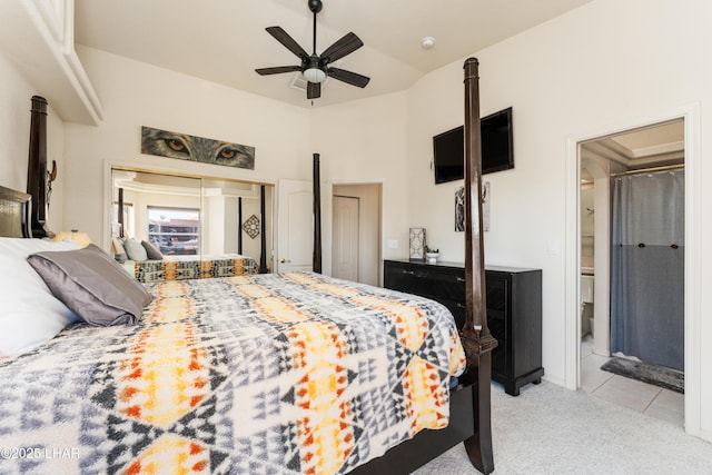 bedroom featuring light colored carpet, ensuite bath, a high ceiling, and light tile patterned floors